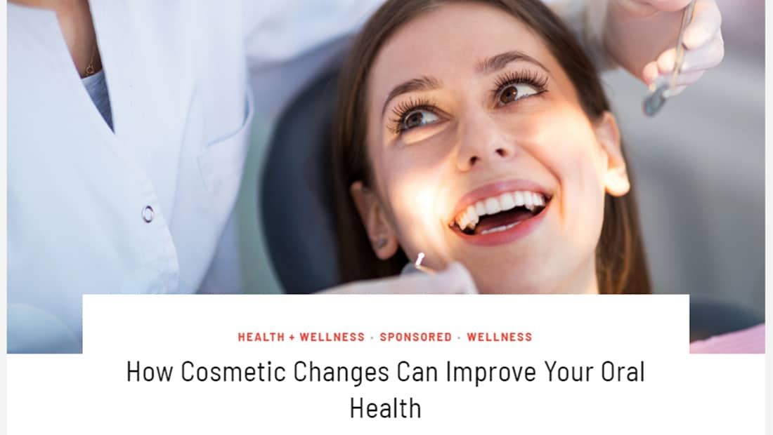 how-cosmetic-changes-can-improve-your-oral-health - Rochester Advanced Dentistry Woman smiling as dentist shine light toward her mouth, with the words "How Cosmetic Changes Can Improve Your Oral Health"