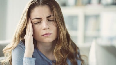 woman holding her forehead in pain