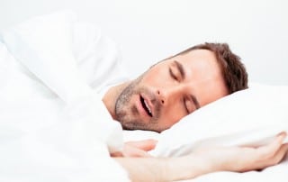 Man snoring while sleeping in bed