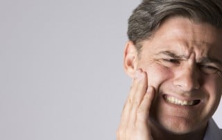man with Jaw Pain caused by TMJ Disorder