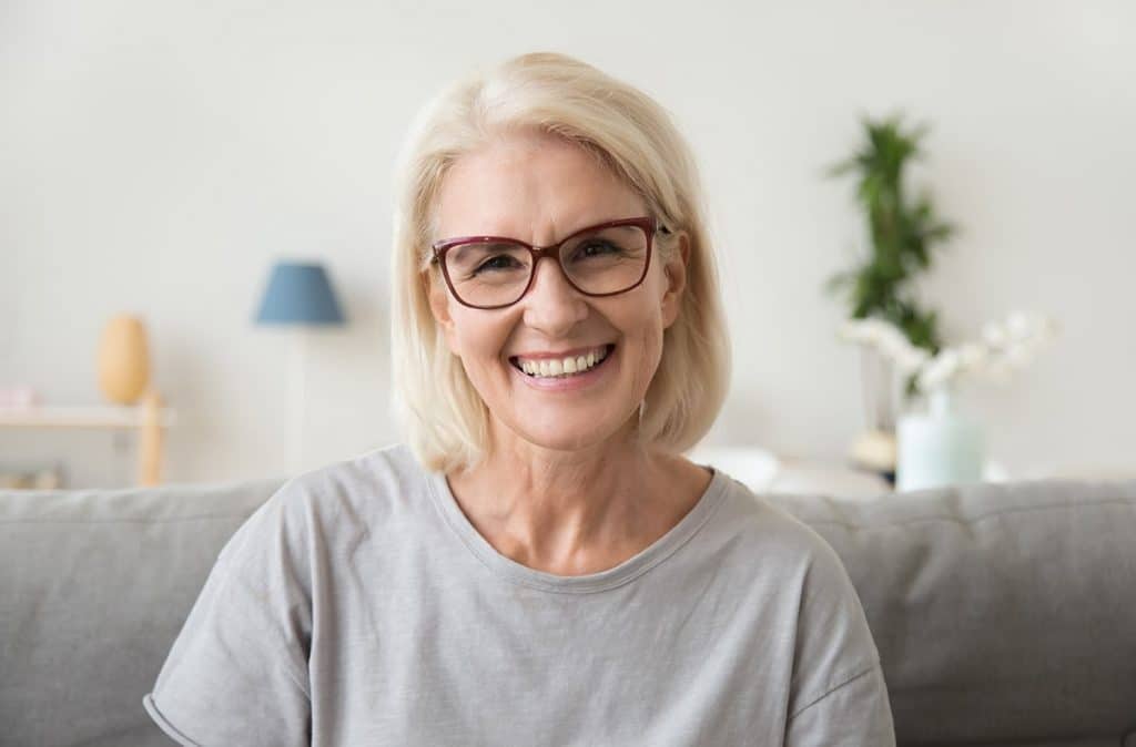 senior woman with new dental implants show off her smile