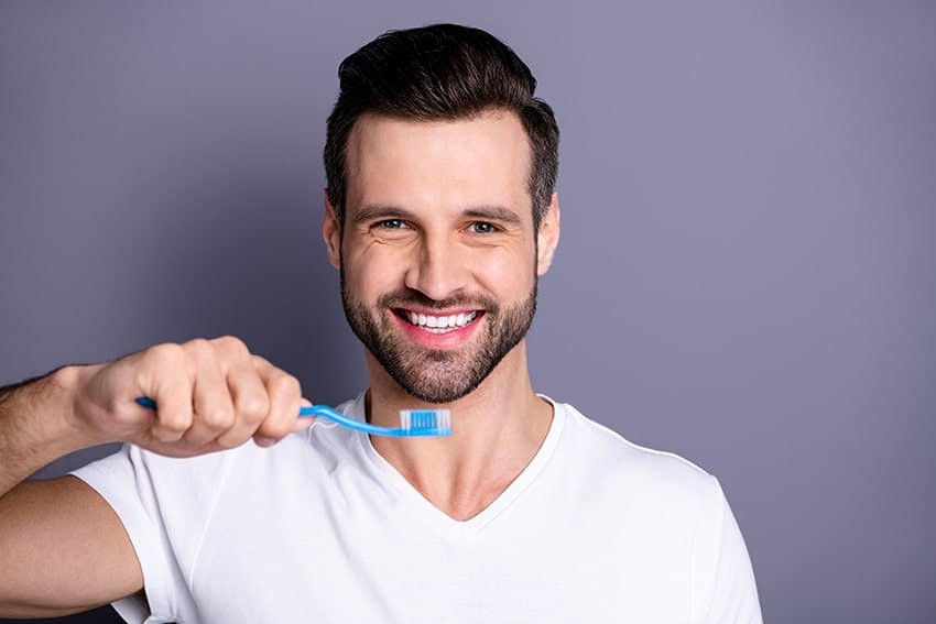attractive man prepares to brush his teeth
