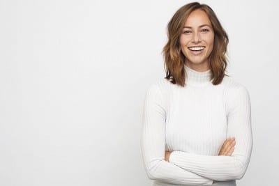 happy woman crosses her arms and smiles