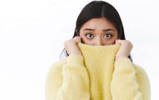 young adult woman feeling anxious and hiding her face