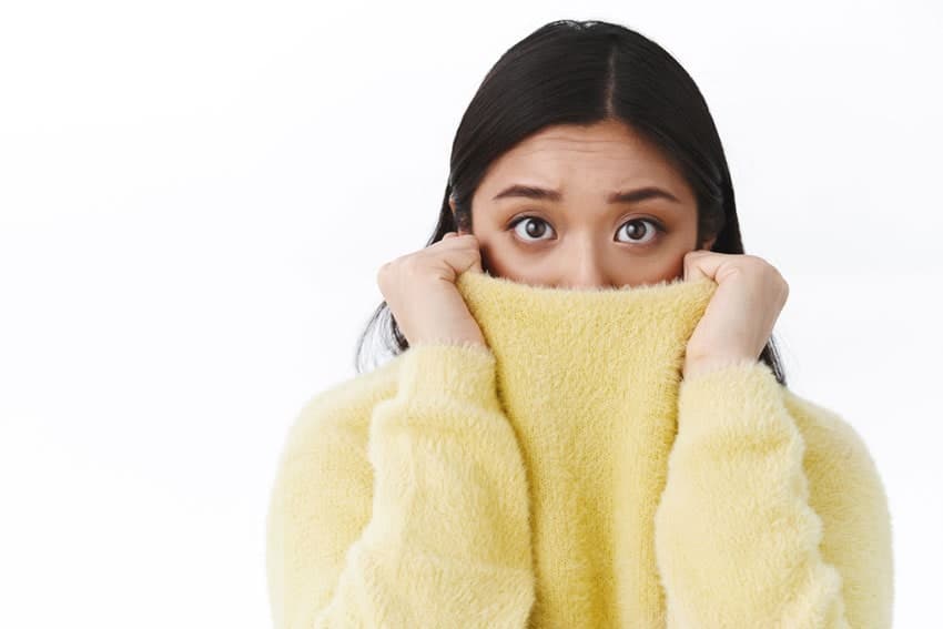 young adult woman feeling anxious and hiding her face
